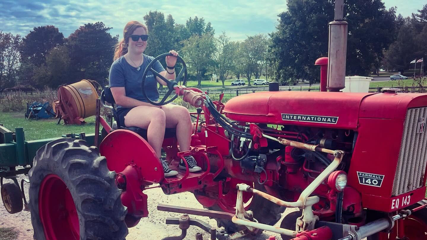 Apprentice Rebecca rides a tractor